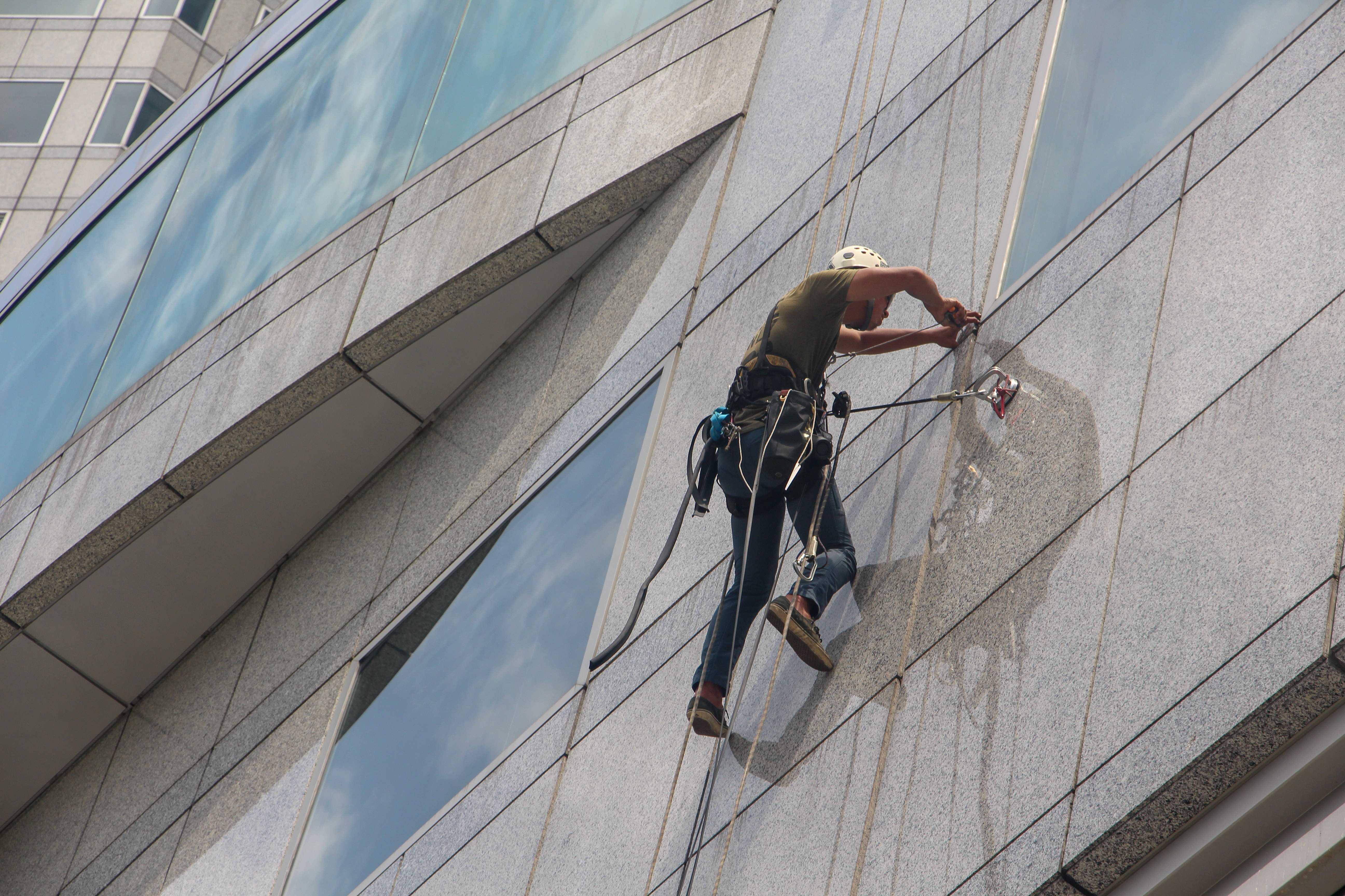 Einer der Caas Reinigung Hannover Mitarbier bei der Reinigung einer Fensterfassade